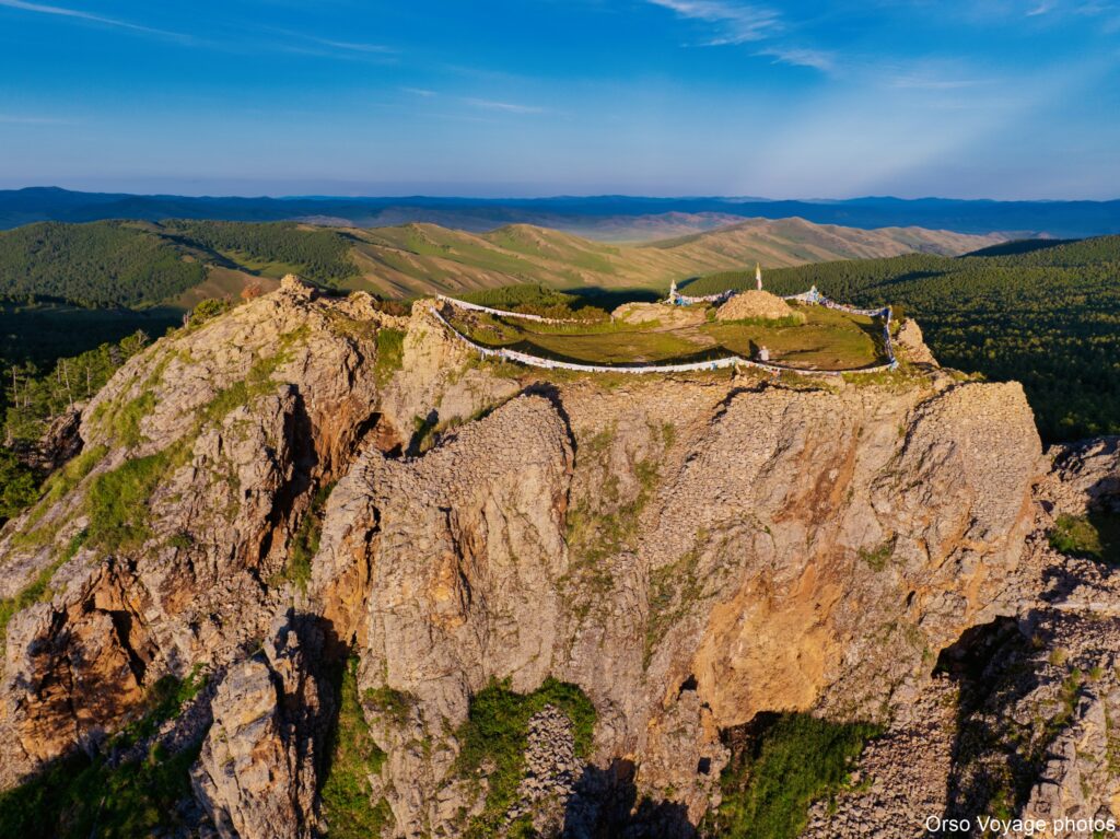Sommet rocheux et temple dans la lumière dorée, Mongolie centrale