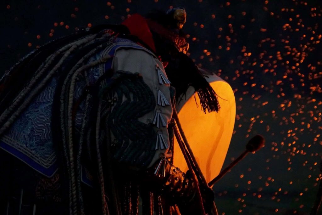 Chaman mongol avec son tambour devant le feu, la nuit